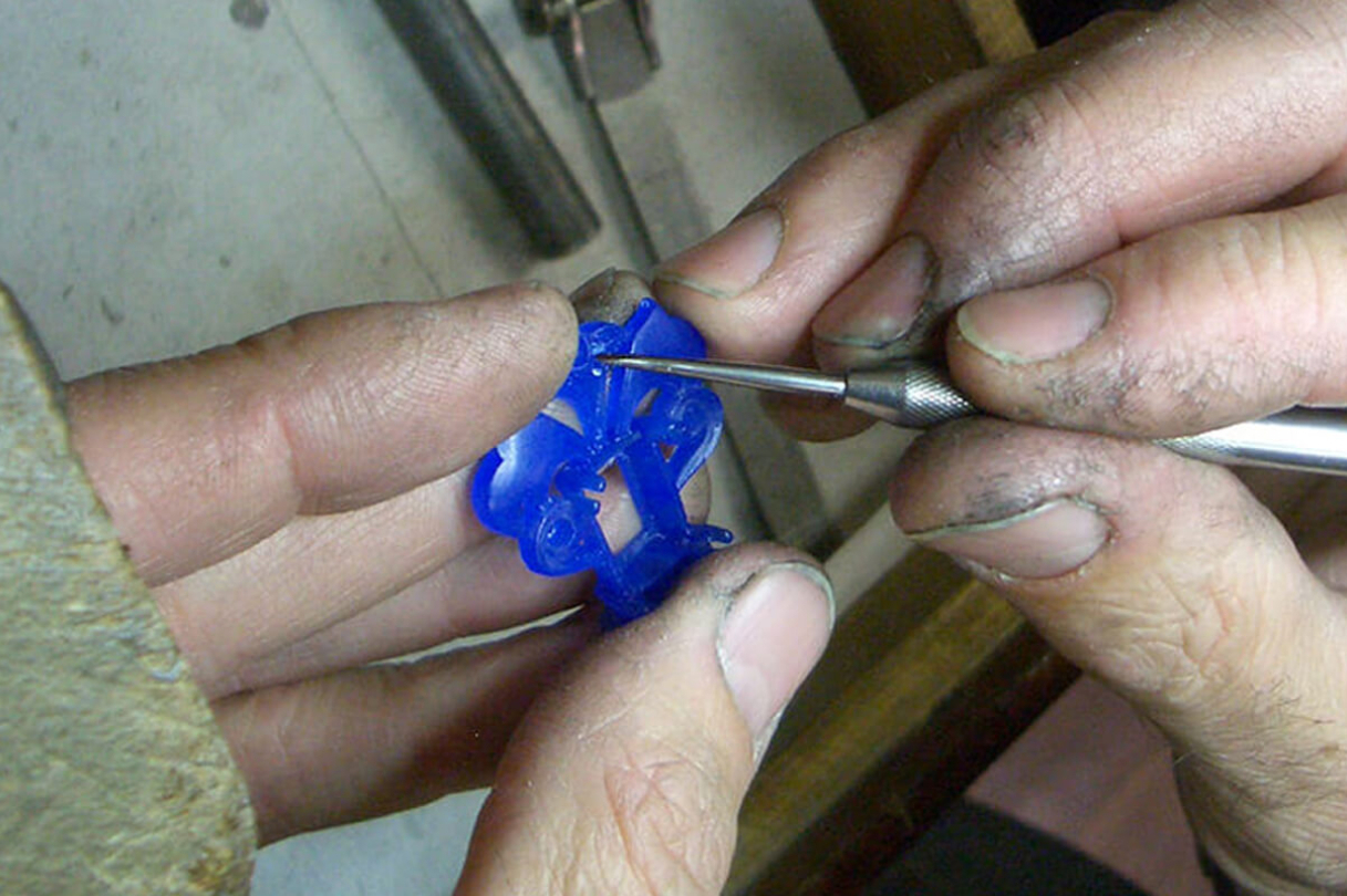 hands working on blue stone