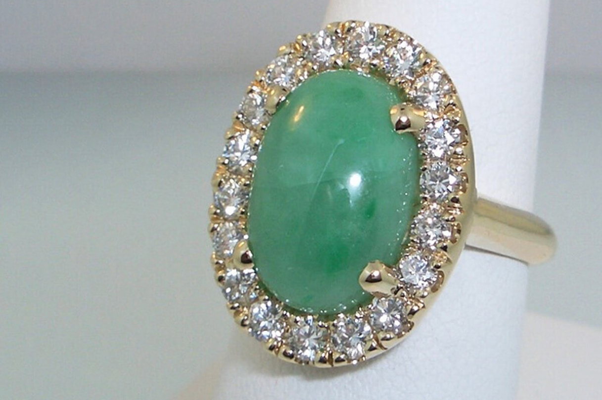 Green stone with diamond halo on gold band